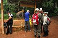  
Popis: a jsme zpět, ukazatel odbočky z hlavní (a vlastně jediné) cesty skrz park, tady asi každý uvidí prvního šimpanze, dřevěného 